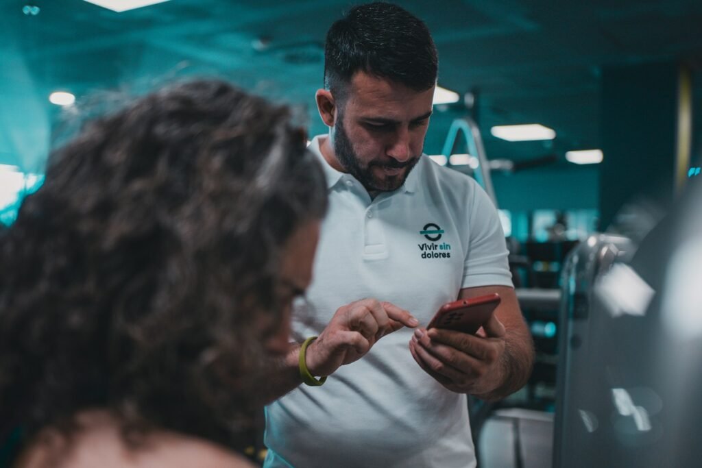 Coach showing a client their training plan on a phone
