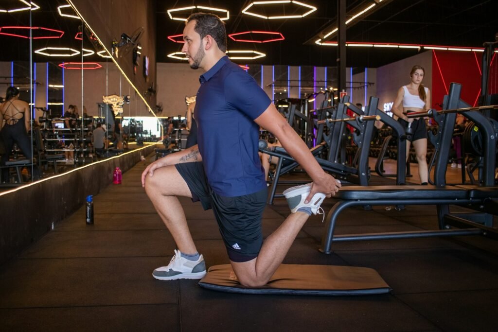 Man stretching his hips in a gym